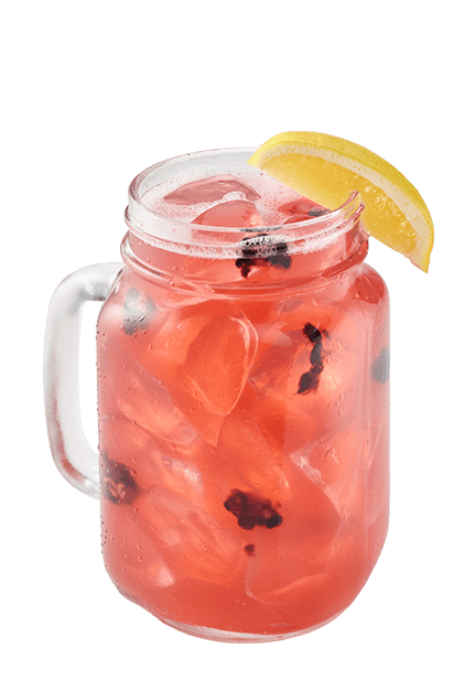 Red cocktail with pieces of blackberries inside a glass mason jar with a handle and a lemon wedge on the rim
